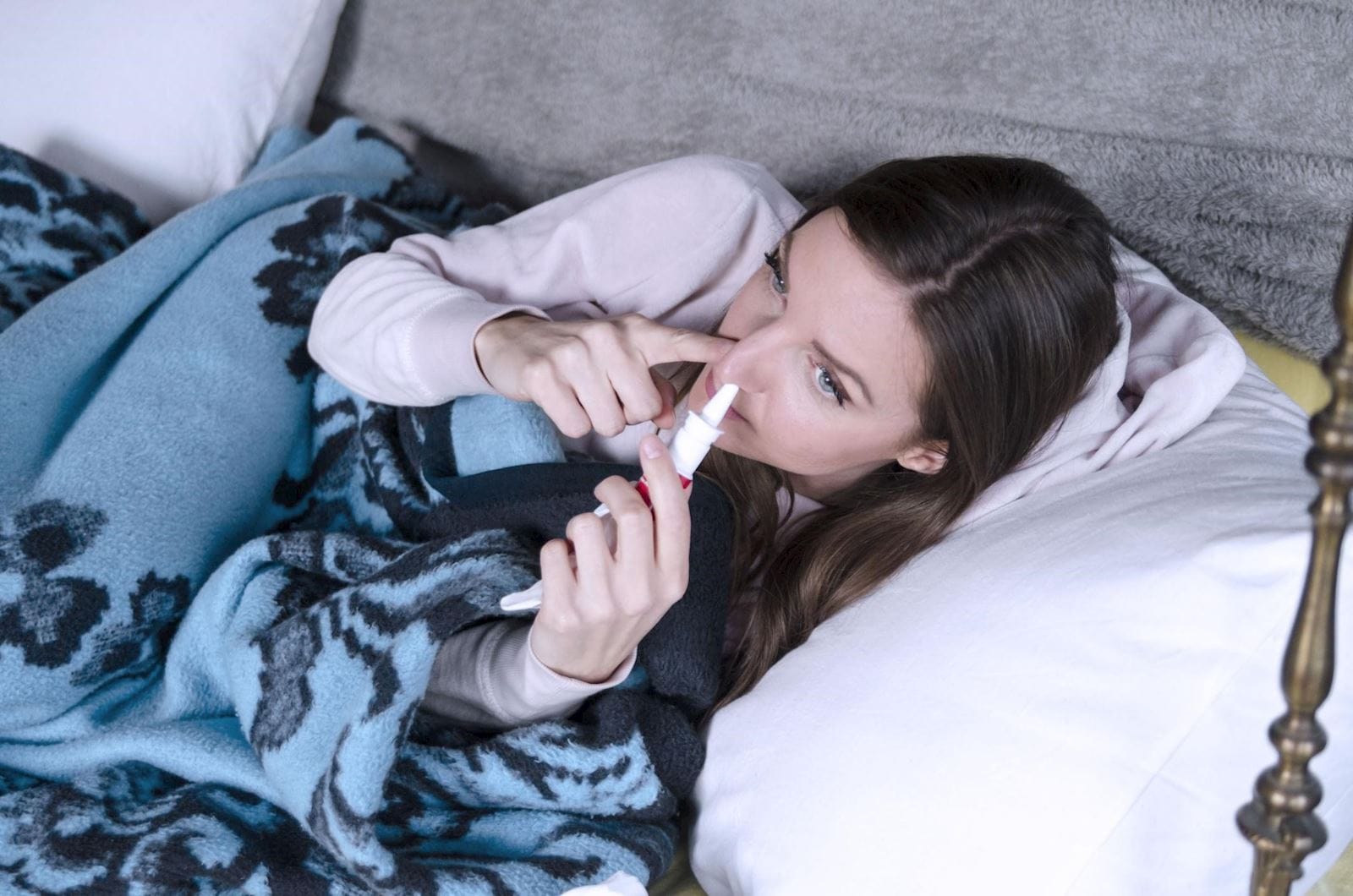 Woman spraying nose with nasal spray