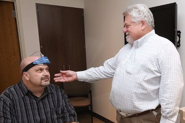 Doctor showing patient how to use sleep study machine