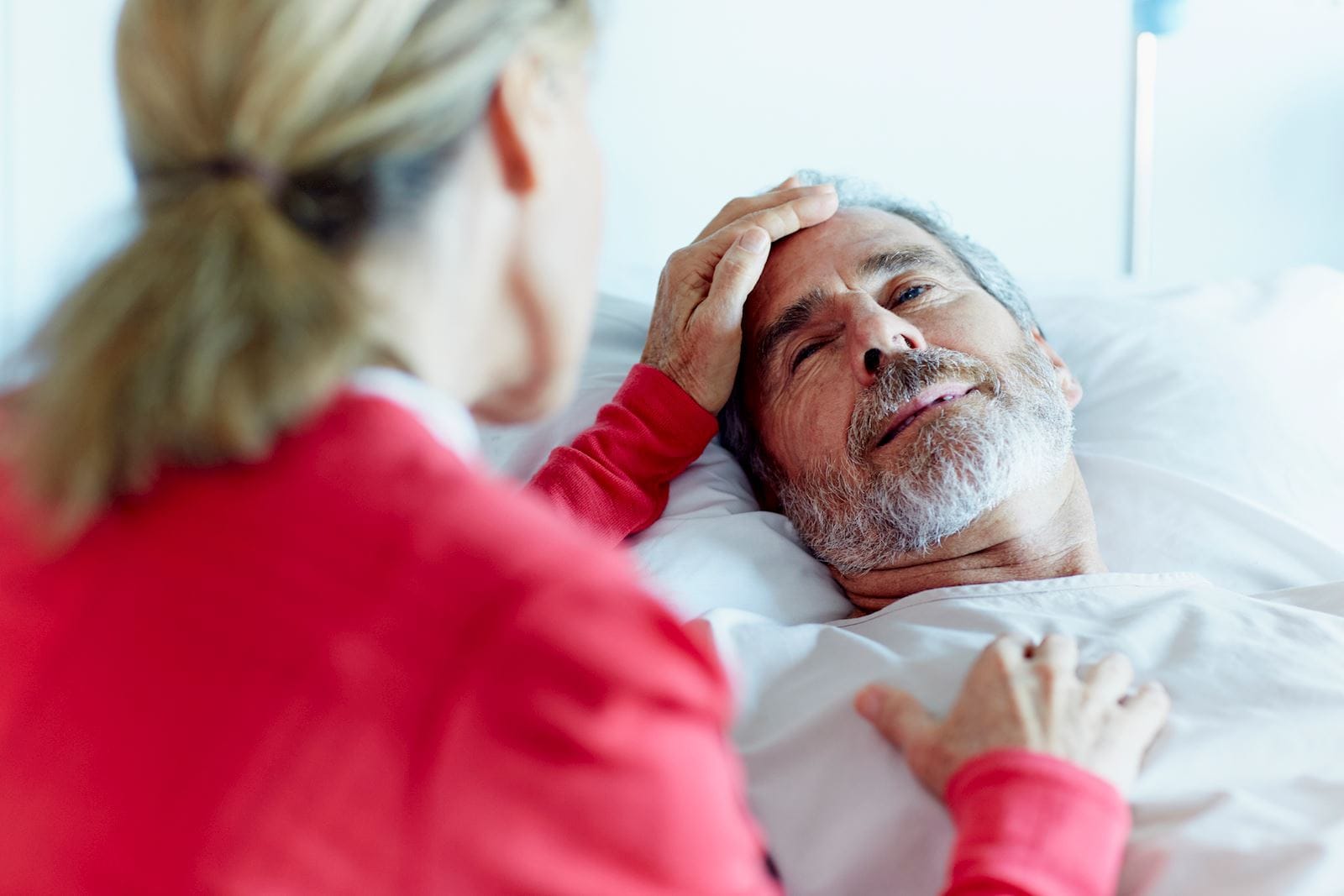 Woman sits by the bedside of a stroke survivor