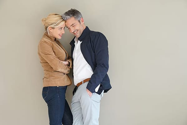 Woman and man standing with foreheads touching; woman is smiling at the man