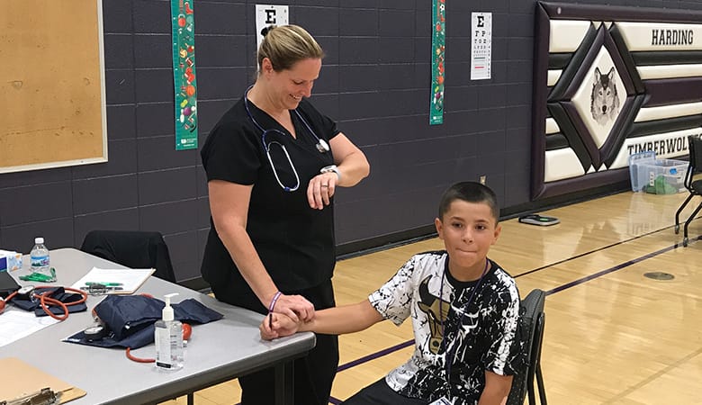 nurse checking heart rate on young male